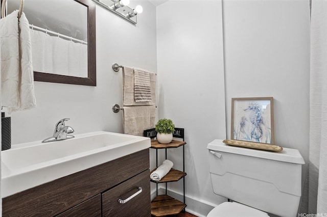 bathroom featuring wood finished floors, toilet, a sink, baseboards, and a shower with shower curtain