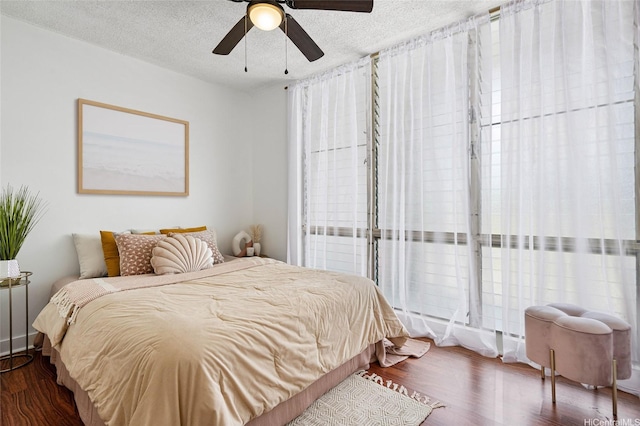 bedroom featuring wood finished floors, a textured ceiling, and ceiling fan