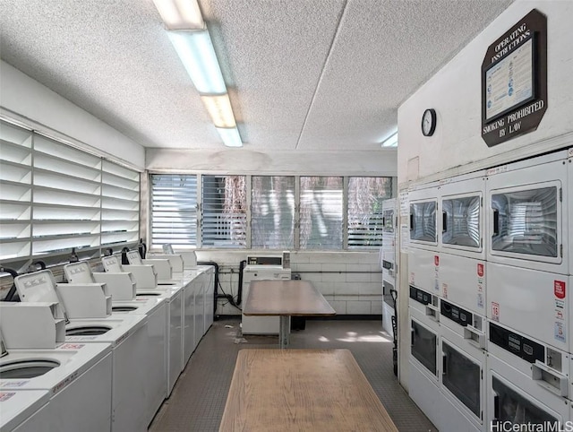 2845 Waialae Ave Unit 116, Honolulu, HI 96826 - shared laundry area featuring a textured ceiling, stacked washer / drying machine, a healthy amount of sunlight, and washer and dryer