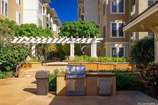 view of patio featuring exterior kitchen, a pergola, and grilling area