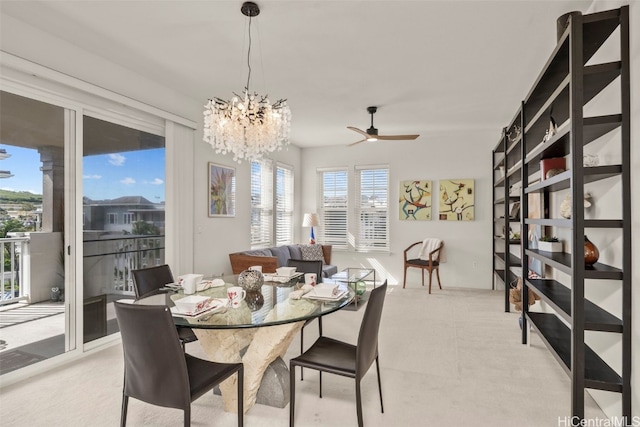 dining space featuring ceiling fan with notable chandelier