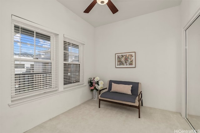 living area featuring carpet and ceiling fan