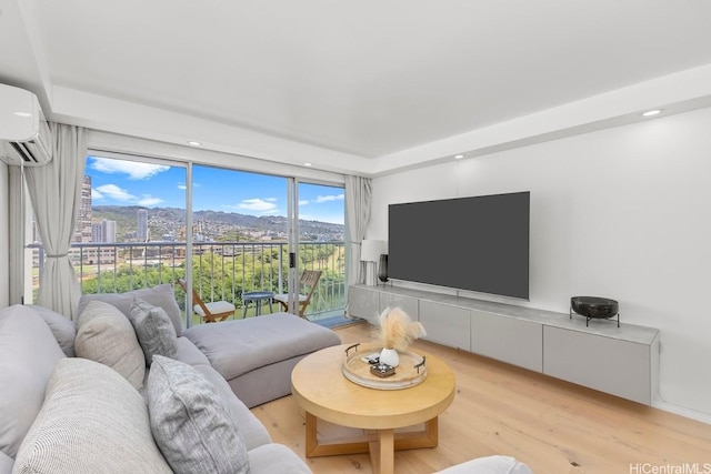 2211 Ala Wai Blvd Unit 906, Honolulu, HI 96815 - living area featuring light wood-style floors, a wall mounted air conditioner, and recessed lighting