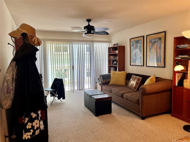 living area with light colored carpet, a textured ceiling, and ceiling fan
