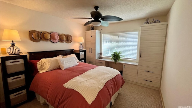 bedroom featuring light colored carpet, a ceiling fan, and a textured ceiling