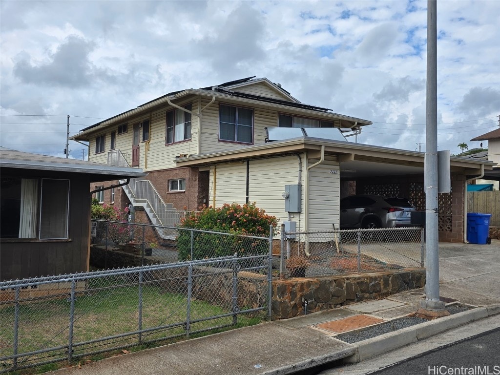 view of front of house with an attached carport, stairs, fence, and concrete driveway