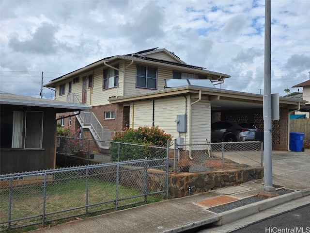 view of front of house with an attached carport, stairs, fence, and concrete driveway