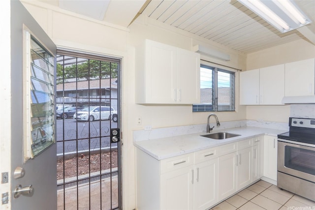 4202 Keanu St Unit 4, Honolulu, HI 96816 - kitchen with stainless steel range with electric stovetop, a sink, white cabinets, light tile patterned floors, and under cabinet range hood