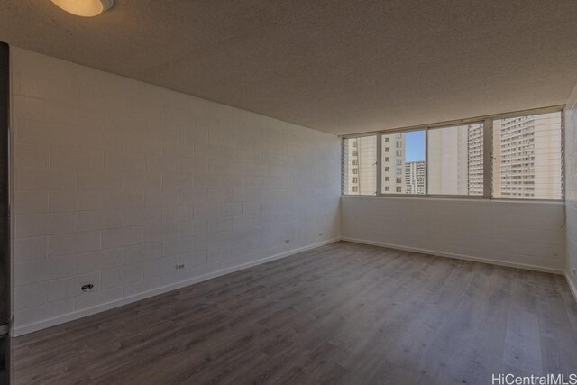 5122 Likini St Unit 616, Honolulu, HI 96818 - empty room with wood finished floors, baseboards, and concrete block wall
