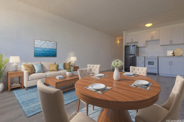 5122 Likini St Unit 616, Honolulu, HI 96818 - dining area featuring light wood-style floors, concrete block wall, and a textured ceiling