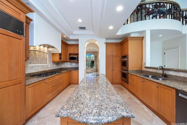 kitchen with an island with sink, stainless steel appliances, backsplash, visible vents, and a sink