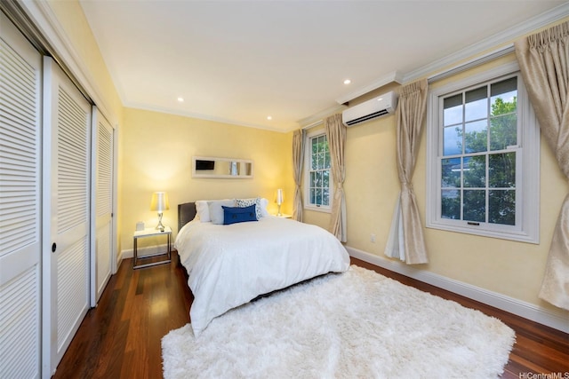 bedroom with wood finished floors, a wall mounted air conditioner, baseboards, and multiple windows
