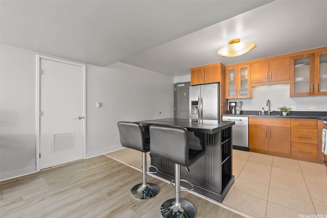 1009 Kapiolani Blvd Unit 4006, Honolulu, HI 96814 - kitchen featuring stainless steel appliances, dark countertops, brown cabinetry, and a kitchen island