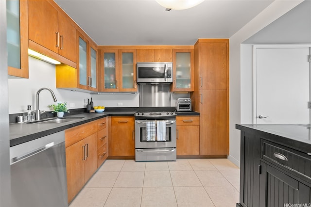 1009 Kapiolani Blvd Unit 4006, Honolulu, HI 96814 - kitchen with stainless steel appliances, dark countertops, brown cabinetry, light tile patterned floors, and glass insert cabinets