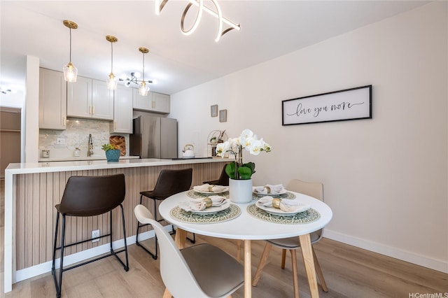 dining room with baseboards and light wood-style flooring