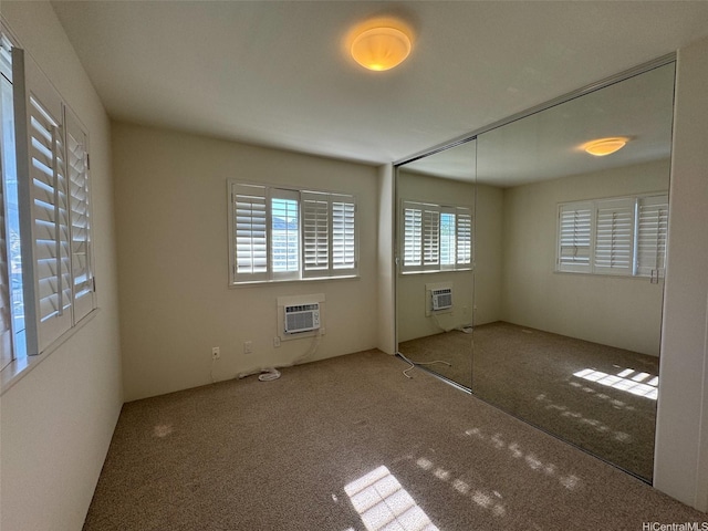 unfurnished room with a wall mounted AC and carpet floors