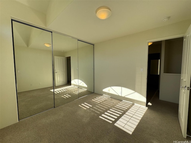 unfurnished bedroom featuring carpet flooring and a closet