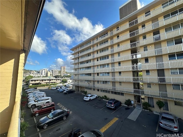 view of building exterior with uncovered parking and a city view