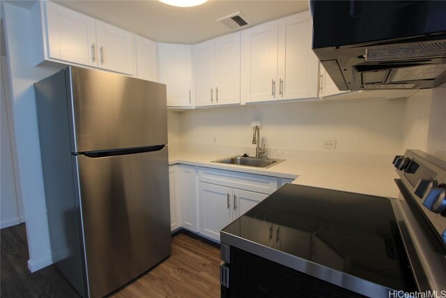 225 Queen St Unit 8C, Honolulu, HI 96813 - kitchen with light countertops, freestanding refrigerator, visible vents, dark wood finished floors, and a sink