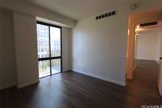 225 Queen St Unit 8C, Honolulu, HI 96813 - unfurnished room with visible vents, baseboards, a textured ceiling, and dark wood-style floors