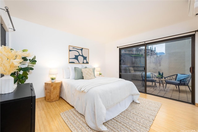 46-058 Aliikane Pl Unit 2114, Kaneohe, HI 96744 - bedroom featuring access to outside, light wood finished floors, a wall unit AC, and baseboards