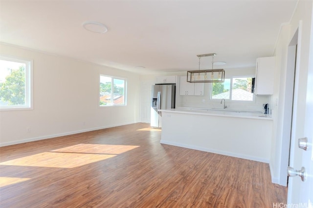 unfurnished living room with baseboards and light wood-type flooring