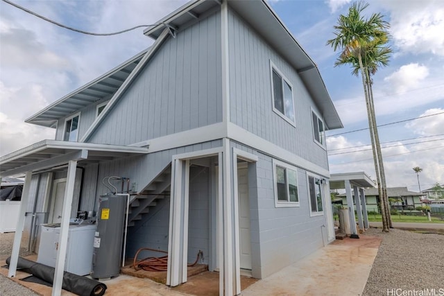 view of side of home featuring water heater and washer / dryer