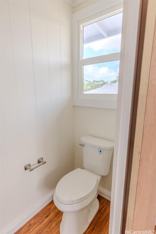bathroom with toilet, wood finished floors, and baseboards