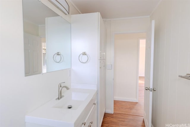 bathroom featuring vanity, ornamental molding, and wood finished floors
