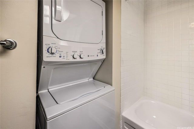 washroom featuring stacked washer and dryer and laundry area