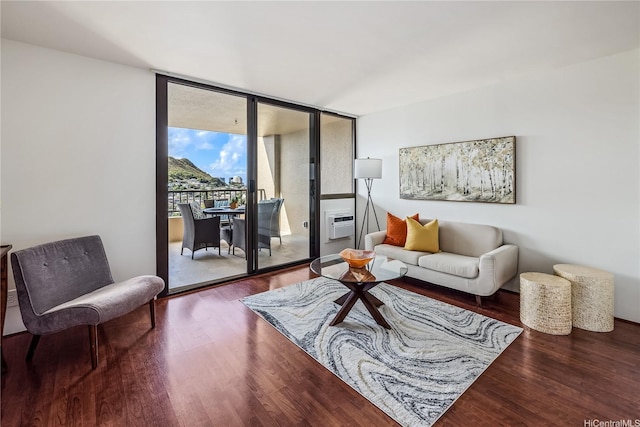 living room with a wall of windows and wood finished floors