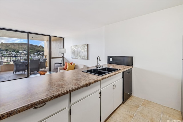 kitchen with dishwasher, a sink, white cabinets, and light tile patterned floors