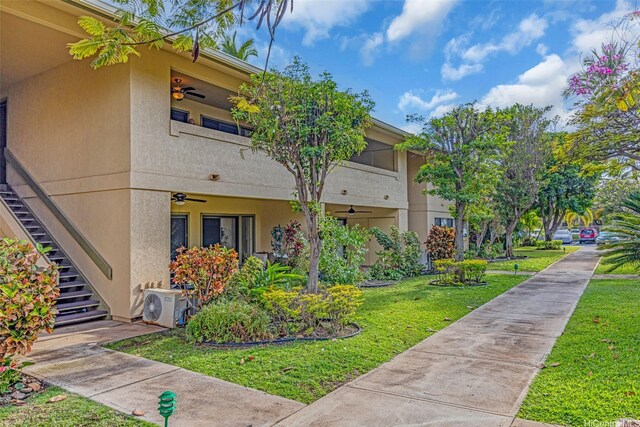 1450 S Kihei Rd Unit C204, Kihei, HI 96753 - view of side of property featuring stairs, stucco siding, a yard, and a cooling unit