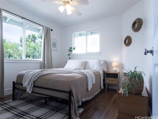 bedroom featuring wood finished floors, ceiling fan, and multiple windows