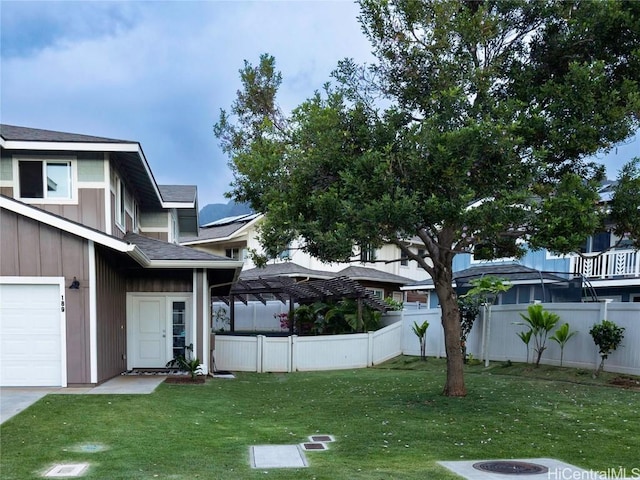 view of front of home featuring a front lawn, fence, and a garage