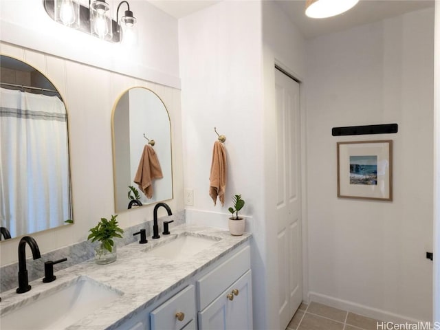 bathroom featuring tile patterned floors, double vanity, and a sink