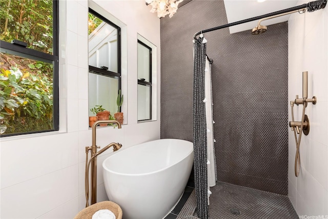 bathroom featuring a stall shower and a freestanding bath