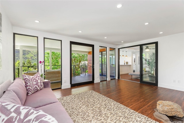 living room featuring recessed lighting, a wealth of natural light, wood finished floors, and baseboards