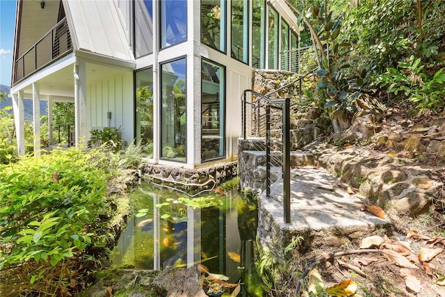 view of side of property with a garden pond