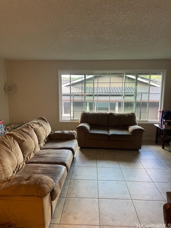 living area featuring a textured ceiling and light tile patterned floors