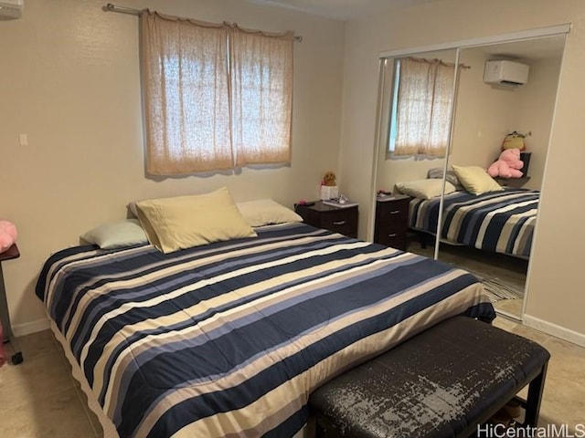 bedroom featuring multiple windows, baseboards, a closet, and a wall mounted air conditioner