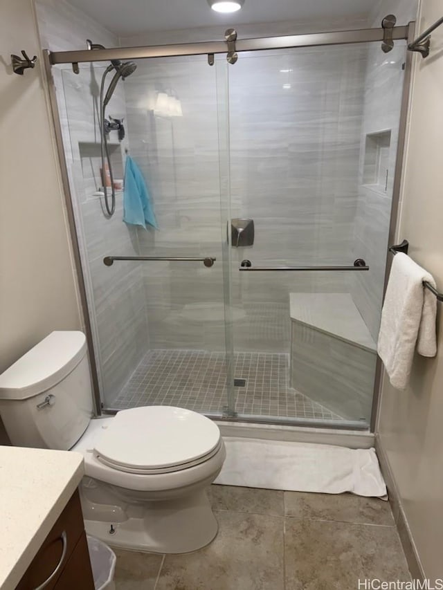 bathroom featuring vanity, tile patterned flooring, a shower stall, and toilet