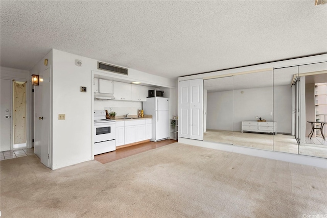 unfurnished living room with visible vents, a sink, a textured ceiling, and light carpet