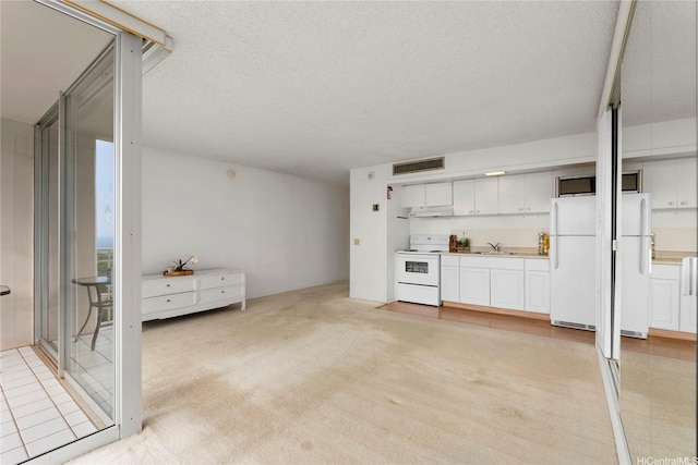 unfurnished living room featuring wet bar, a textured ceiling, visible vents, a sink, and light carpet
