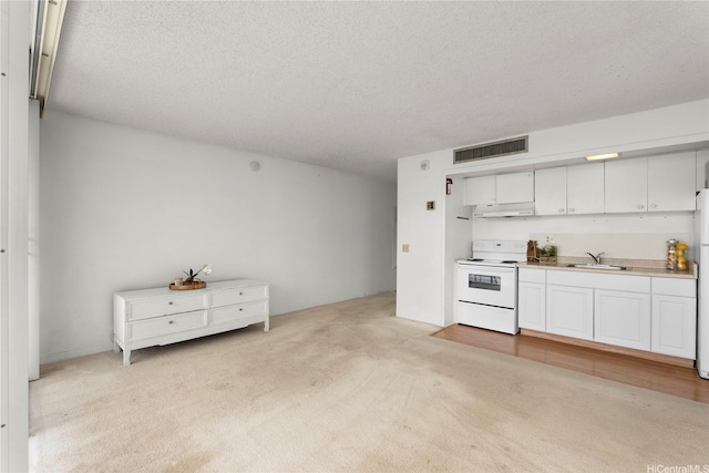 kitchen featuring visible vents, light carpet, white appliances, a textured ceiling, and under cabinet range hood