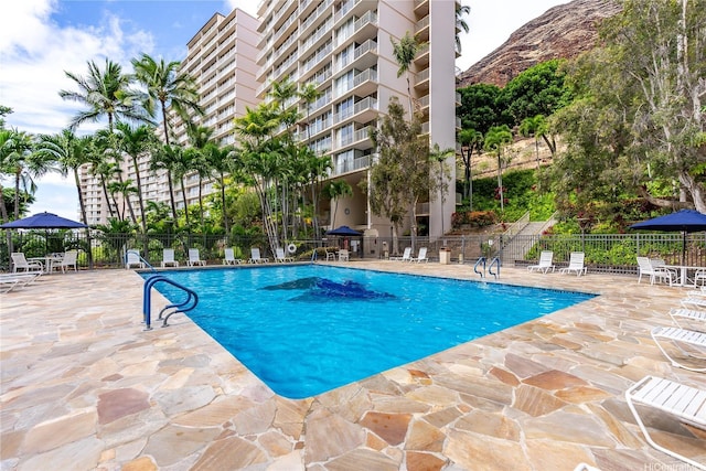 pool with fence and a patio