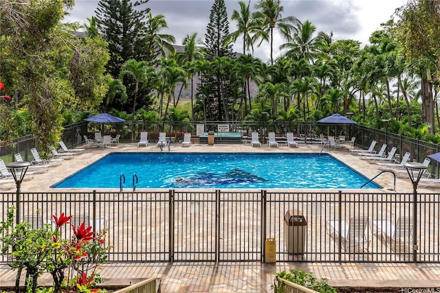 community pool with fence and a patio