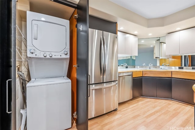 66 Queen St Unit 1903, Honolulu, HI 96813 - kitchen with modern cabinets, white cabinetry, stacked washer / dryer, appliances with stainless steel finishes, and light countertops