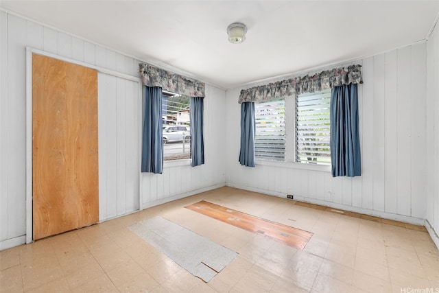 spare room featuring wooden walls and tile patterned floors