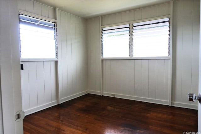 empty room featuring dark wood-type flooring and baseboards